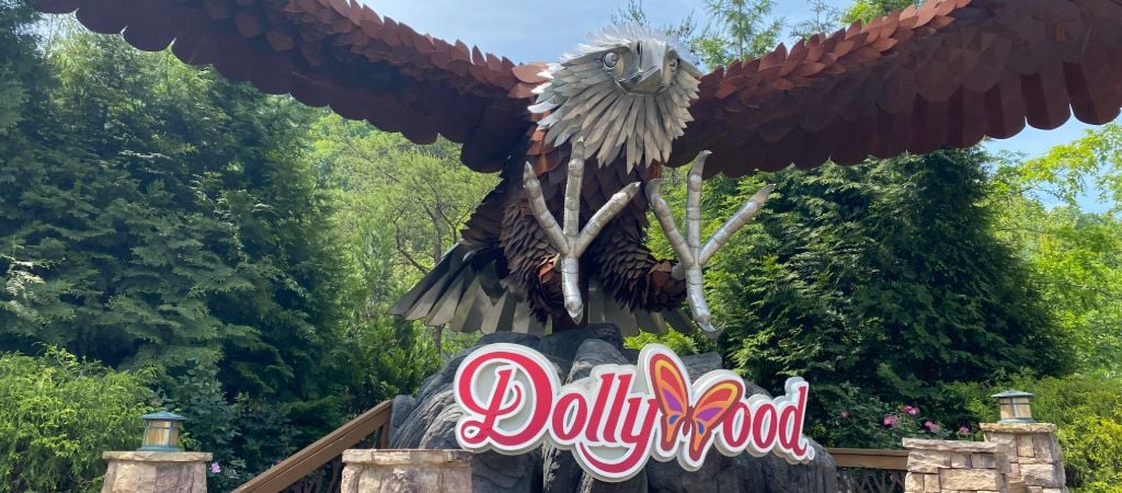 A Dollywood sign sits beneath a giant bald eagle sculpture.