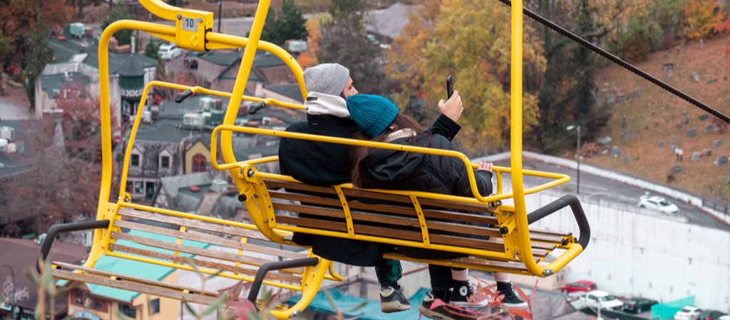 A couple cuddle and take a video while riding a Gatlinburg chairlift.