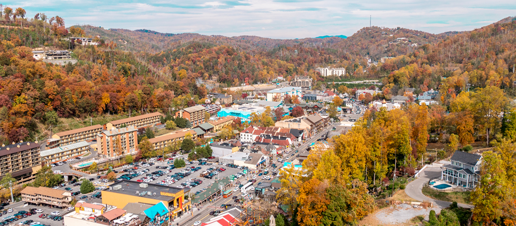 An aerial view of downtown Gatlinburg, with mountains all around, in fall.