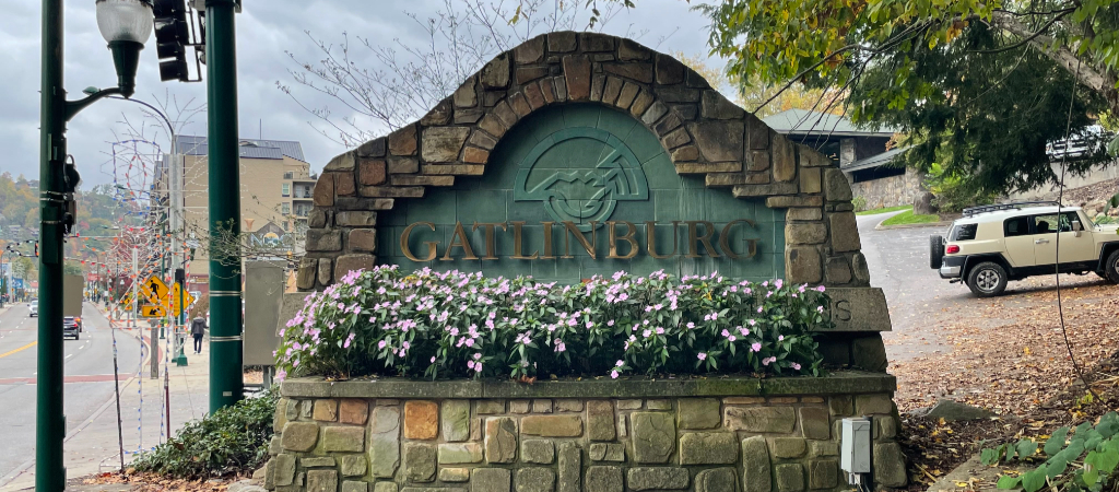 Downtown Gatlinburg Sign at a Town Entrance One of the classic downtown Gatlinburg signs with pink flowers planted in front that reads Gatlinburg.