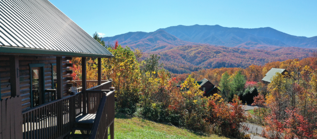Fall Colors in the Smoky Mountains with Cabins Gorgeous Great Smoky Mountain views painted with the colorful leaves of fall, with a log cabin to the side and more log cabins among the trees.