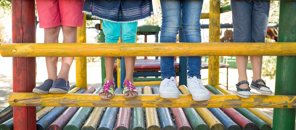 Kids Standing on a Colorful Jungle Gym A half view of kids' legs standing on a colorful playground jungle gym.