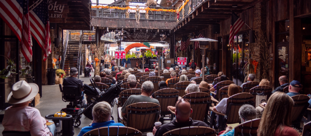Visitors Enjoy a Music Event at Ole Smoky in Gatlinburg A large group of people are seated at a free outdoor live music event at Ole Smoky Moonshine in downtown Gatlinburg.